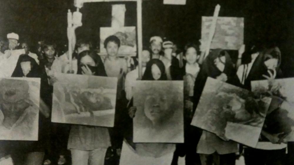 1986 rally against the Marcos Dictatorship in which protesters hold up images of Escalante Massacre victims