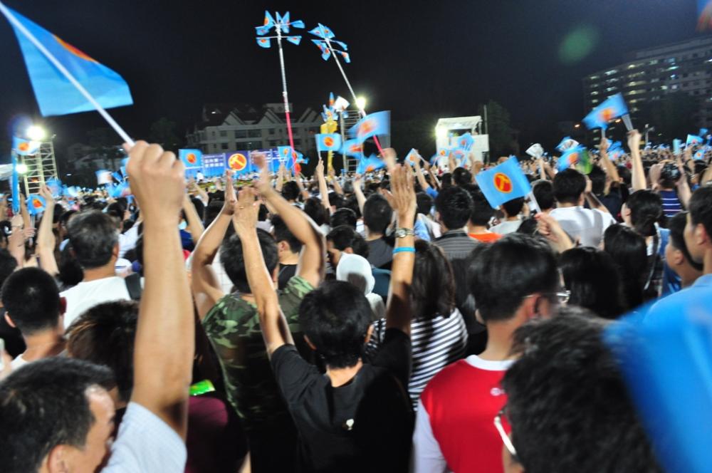 People waving flags at a Workers' Party of Singapore rally at Serangoon Stadium for the Singaporean general election, 2011.