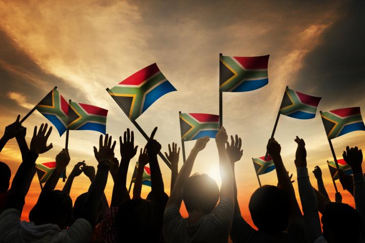 Group of people waving South African flags